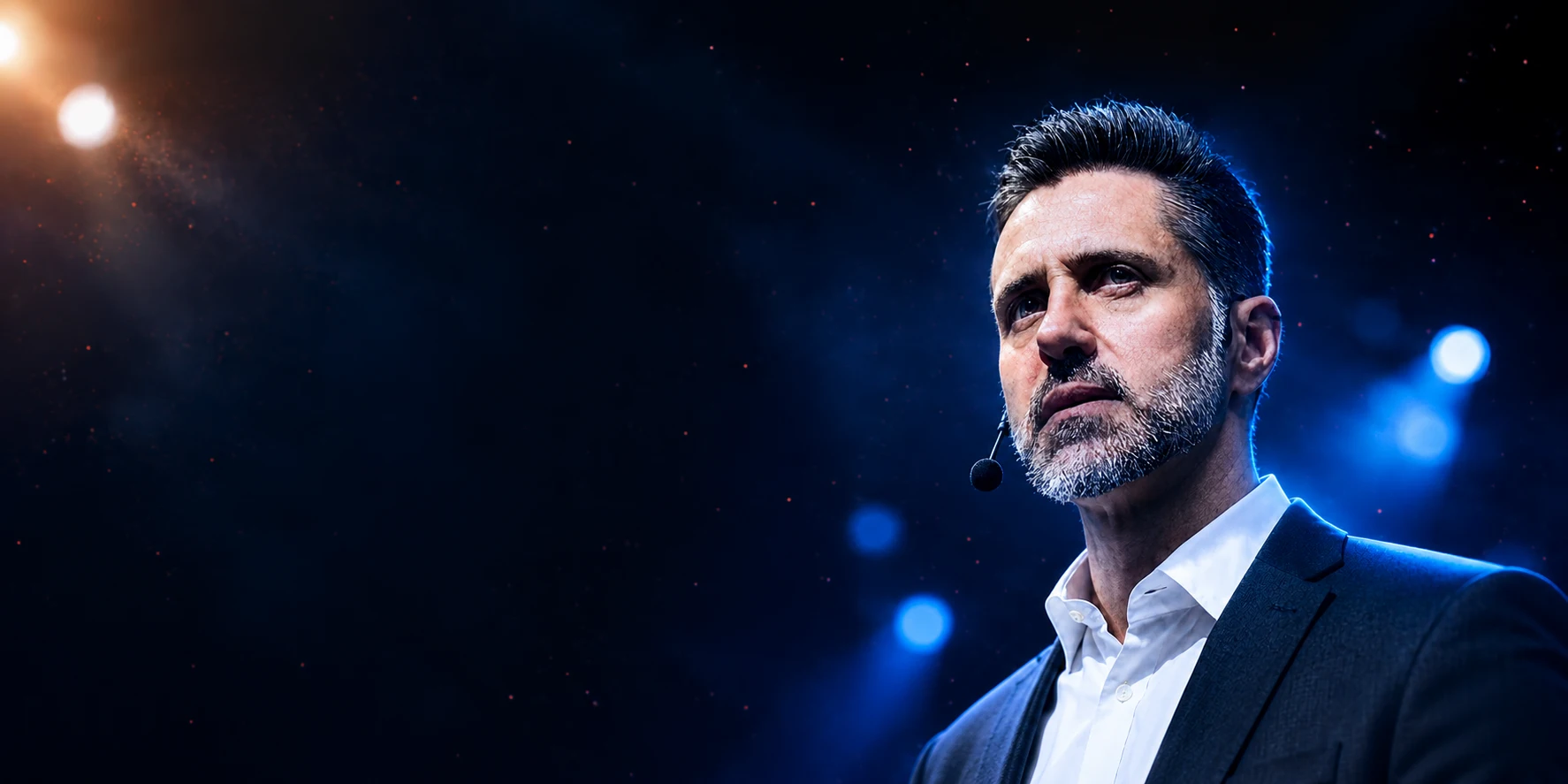 Fábio Fray no palco, de terno azul e microfone